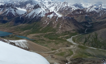 Shimshal pass with green land and snow covered with mountains