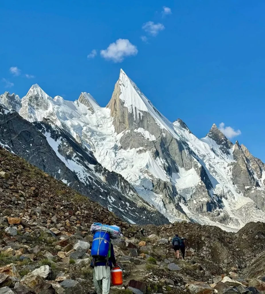 Laila Peak pakistan expedition view from base camp area in Hushe Valley - a porter heaging up with luggages